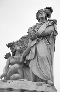 A marble statue in Lima showing Christopher Columbus standing tall over an indigenous woman